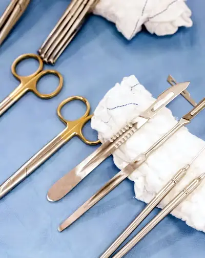 Surgeon in surgical scrubs and a mask, focused on performing surgery